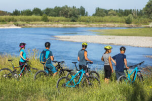 des cyclistes font une pause en bord de Durance pour regarder le paysage qui s'offre à eux